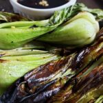 Grilled bok choy on a metal sheet pan.