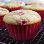 Raspberry cupcakes on a wire cooling rack.