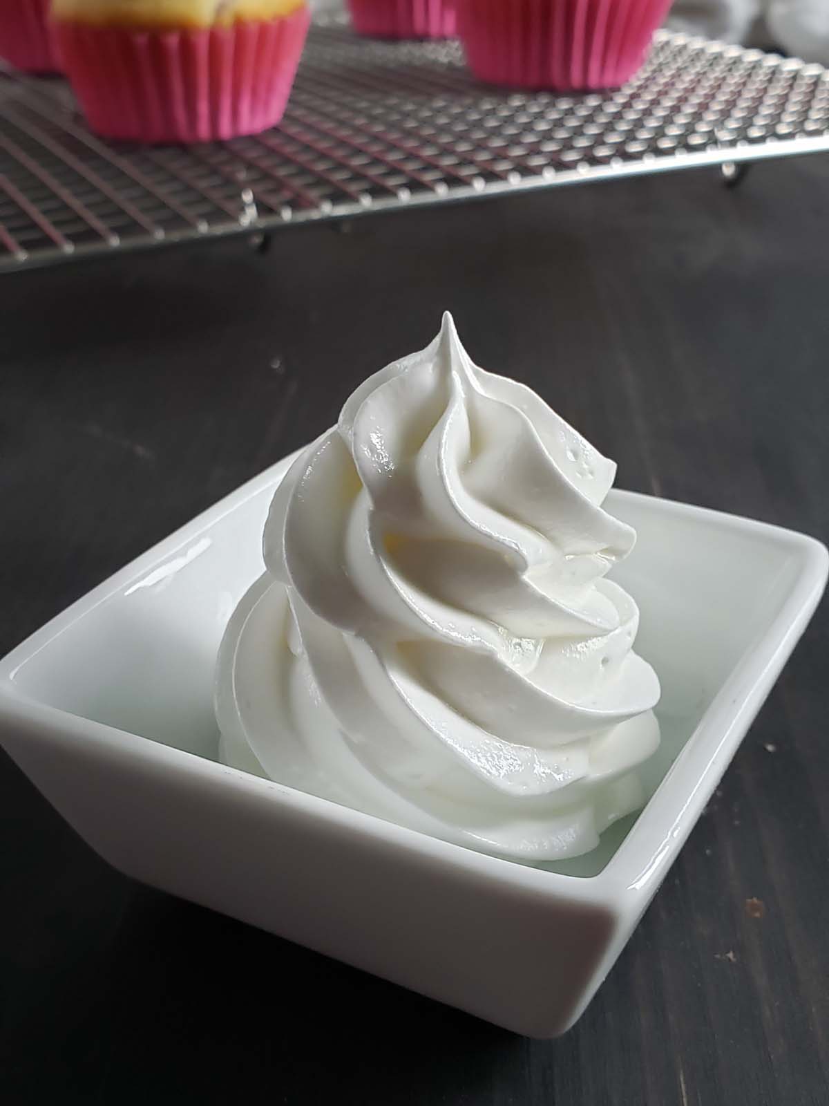 Lemon swiss meringue piped into a square white container.