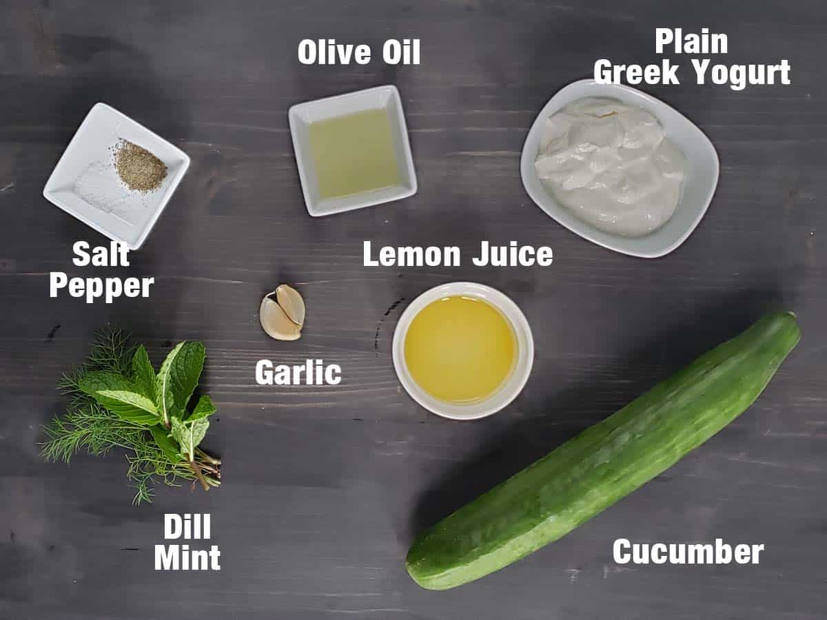 Tzatziki sauce ingredients on a dark background.