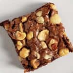 Single hazelnut brownie on a white plate.