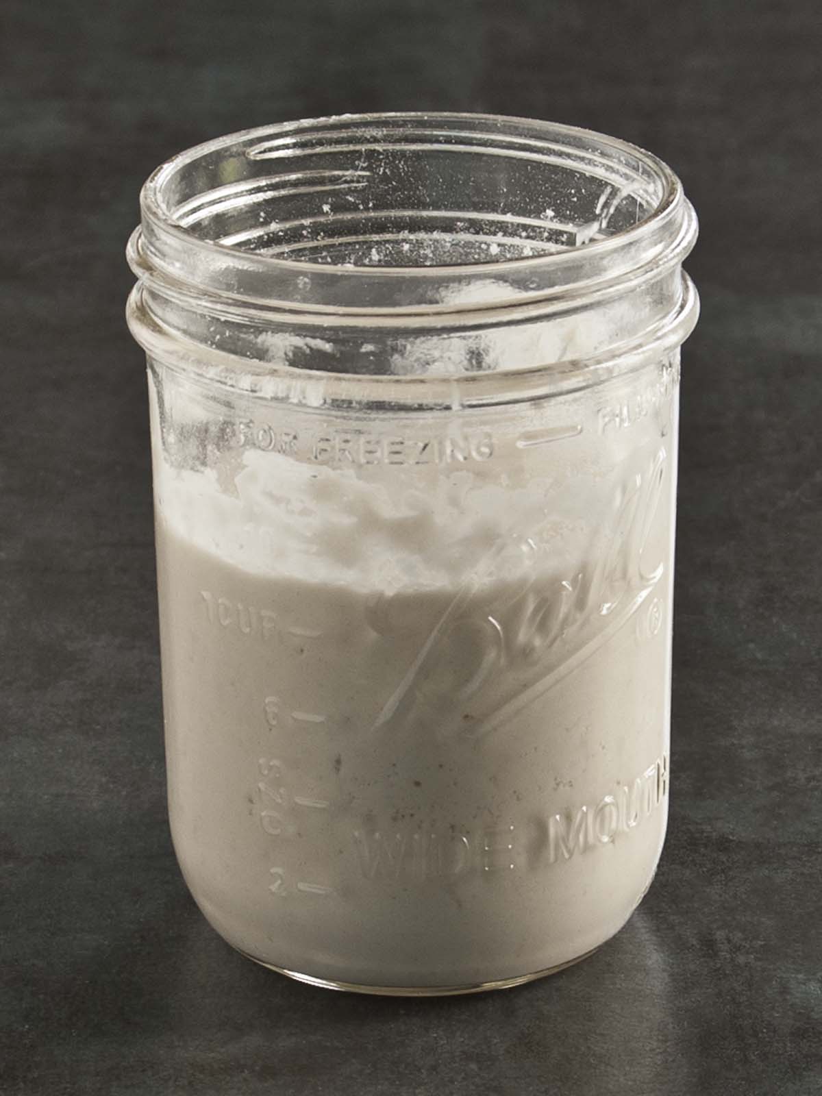 Glass jar filled with sourdough discard.