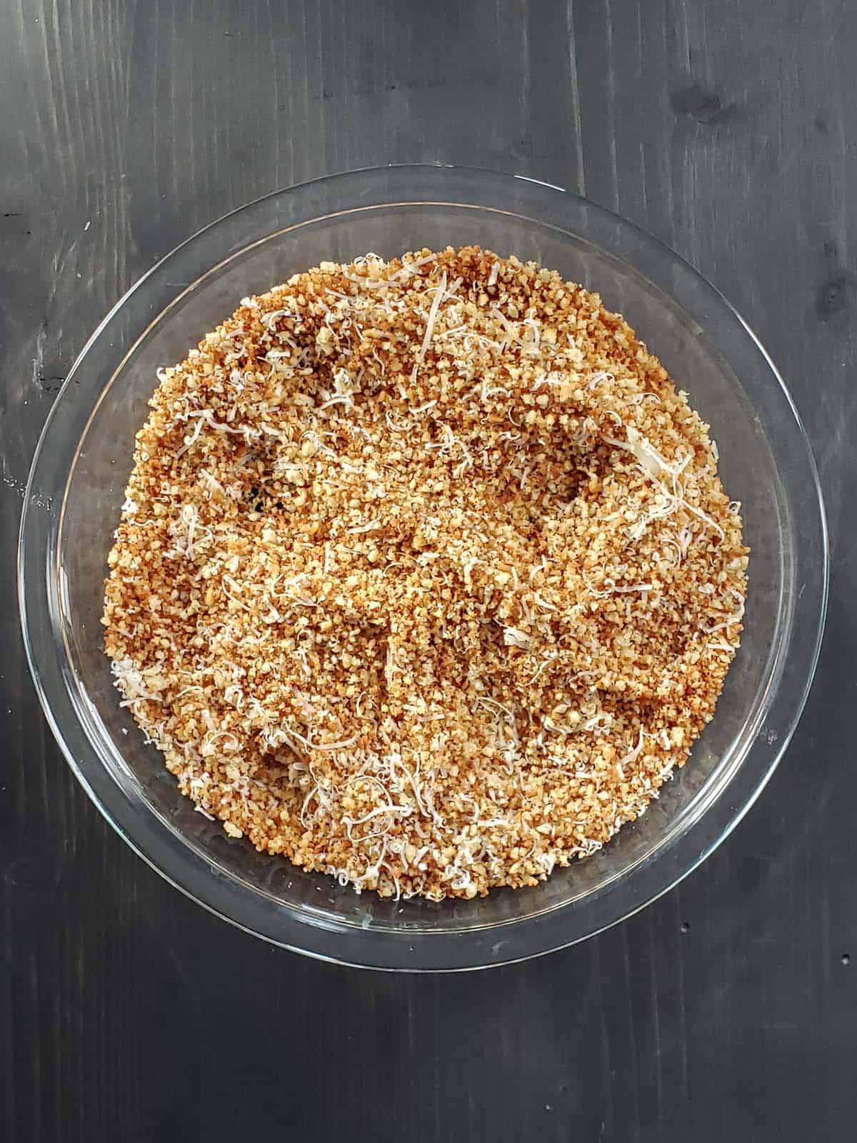 Toasted bread crumbs in a glass pie plate.