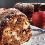 Slice of apple walnut cake on a white plate.