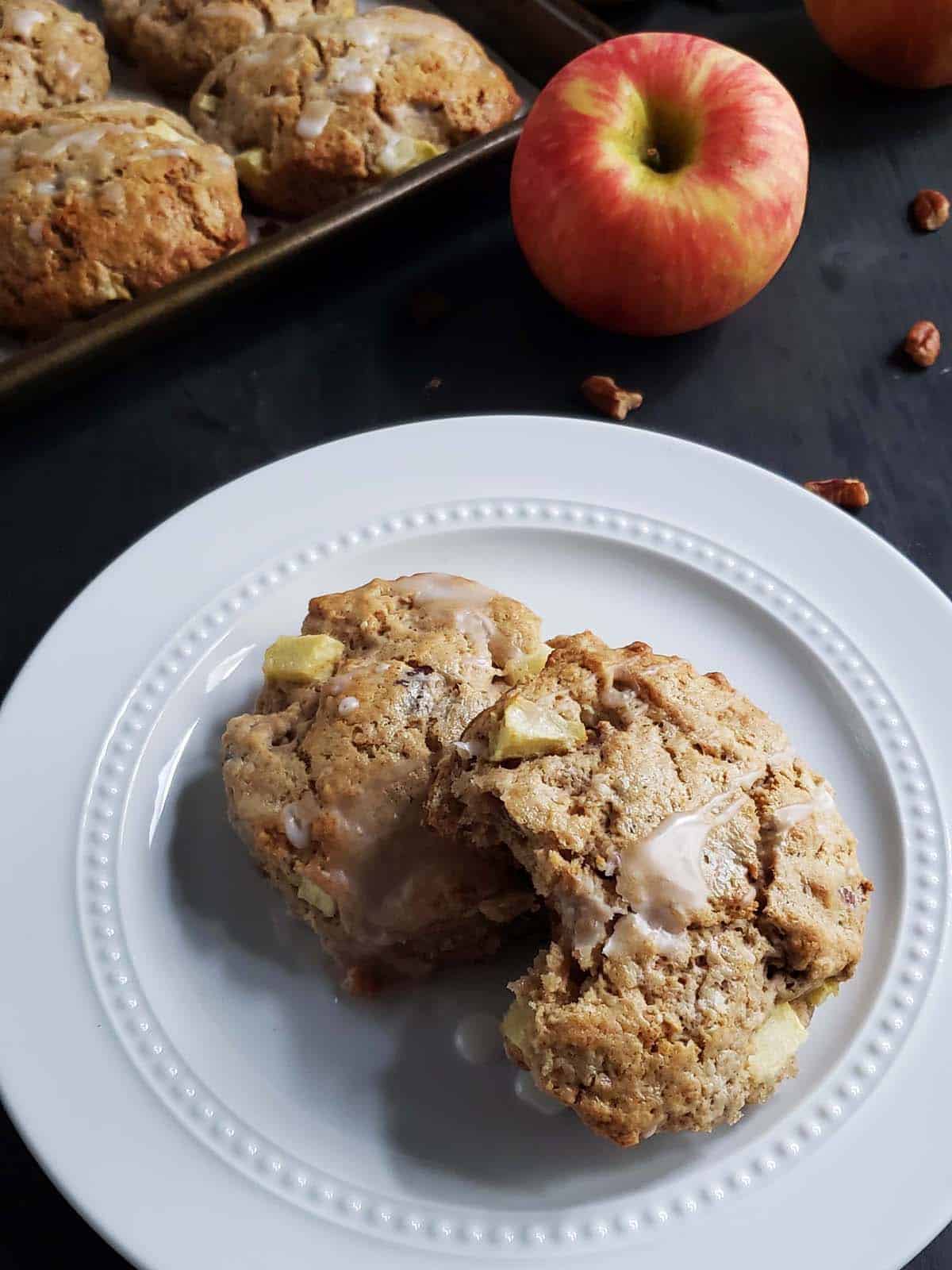 Two apple pecan scones on a white plate.