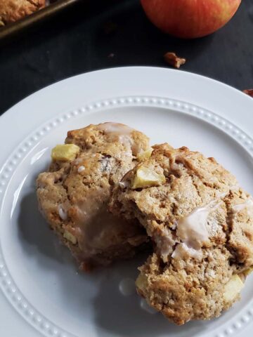 Two apple pecan scones on a white plate.