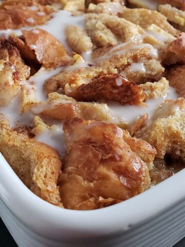 Close up of condensed milk bread pudding in a white baking dish.