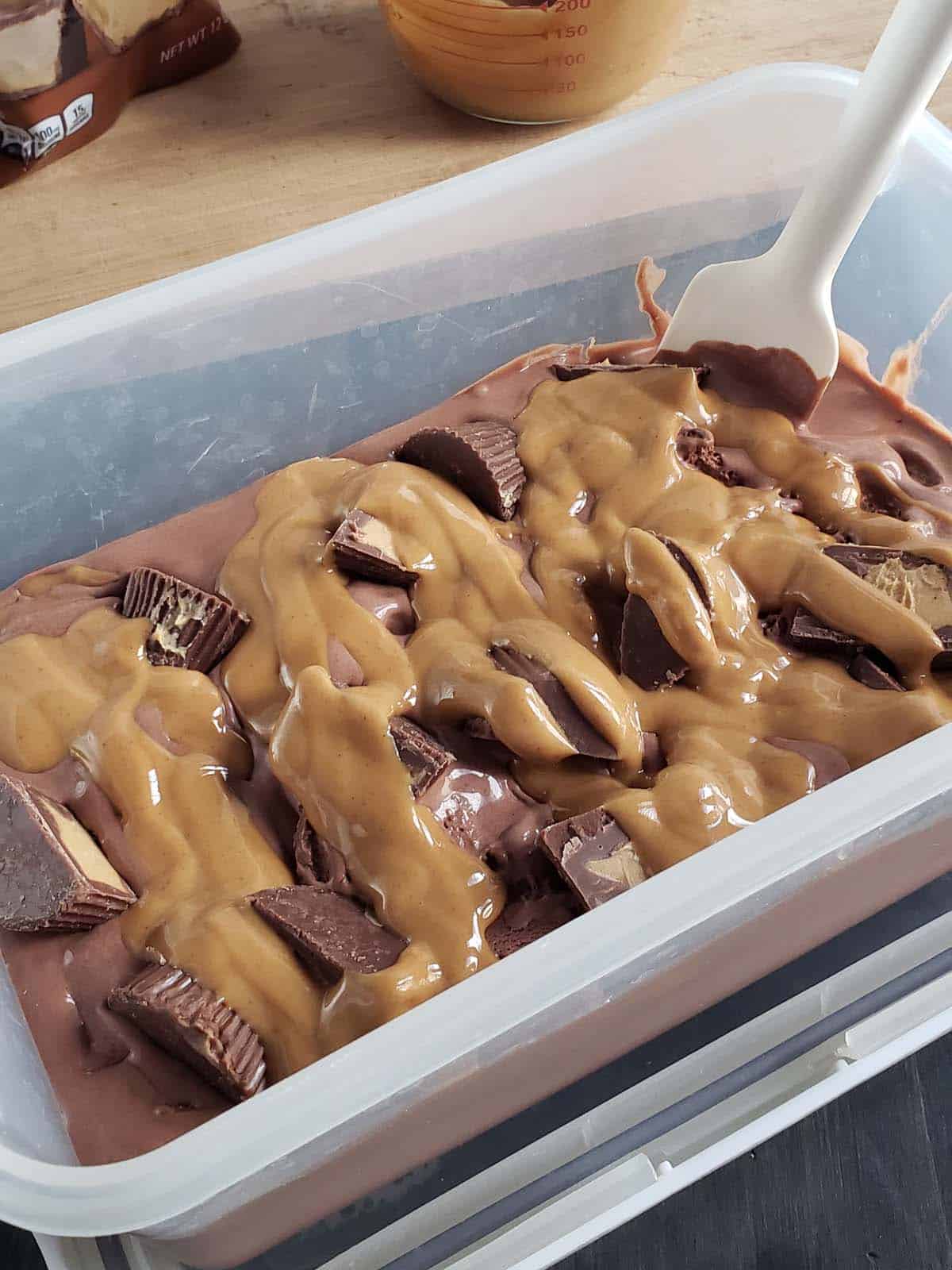 Chocolate ice cream with a peanut butter swirl in a clear plastic container.