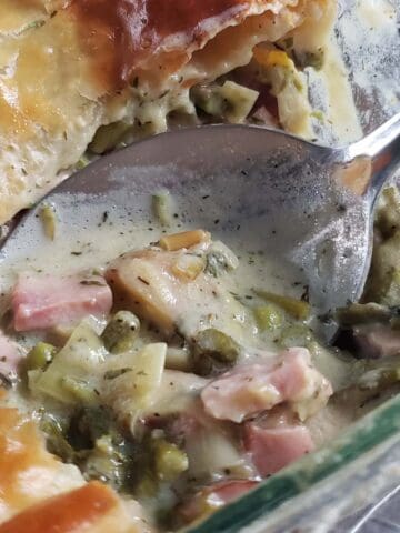 Ham and leek pot pie with a scoop missing.
