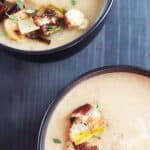 Two black bowls filled with cauliflower leek soup.