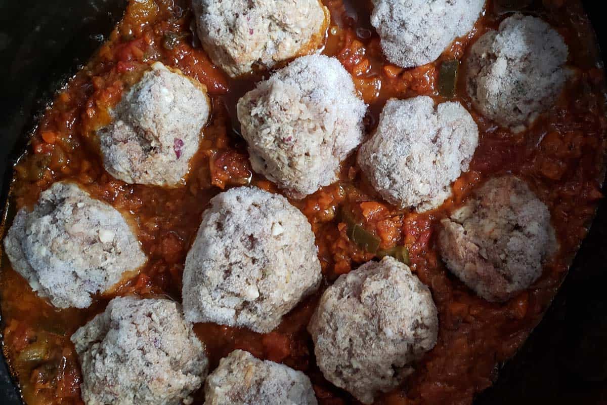 Frozen meatballs in a slow cooker with spaghetti sauce.