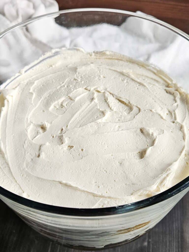 Top layer of cream for tiramisu in a trifle dish.