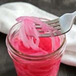 Pickled onions on a fork.