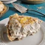 Slice of pineapple cream pie on a white plate.