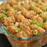 Pork casserole topped with tater tots in a glass casserole dish.