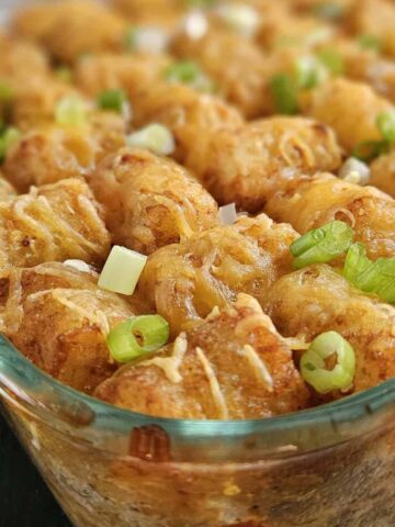 Pork casserole topped with tater tots in a glass casserole dish.