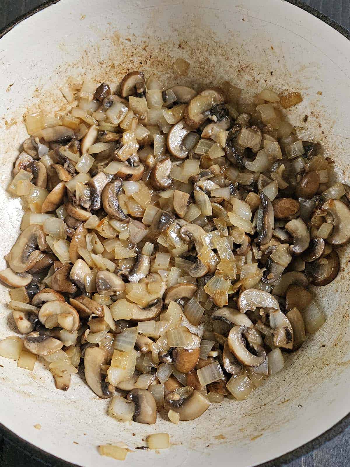 Sauteed onions and mushrooms in a dutch oven.