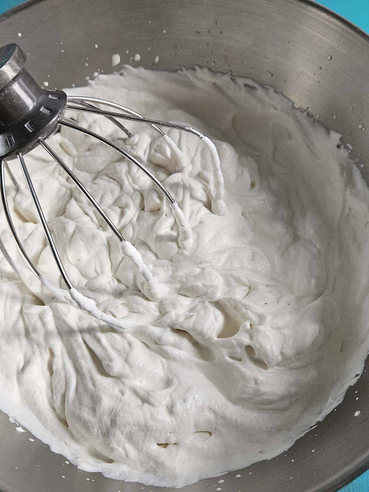 Whipped cream in a metal bowl.