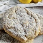 Lemon cookies piled on a white plate.