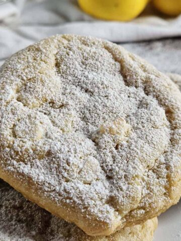 Lemon cookies piled on a white plate.