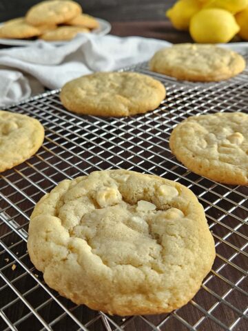 Five lemon cookies on a wire cooling rack.