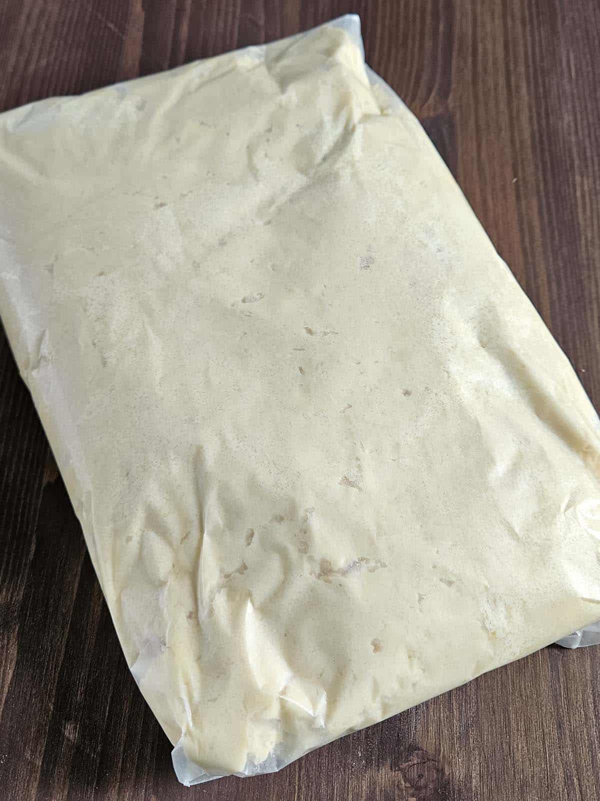 Cookie dough wrapped in waxed paper.