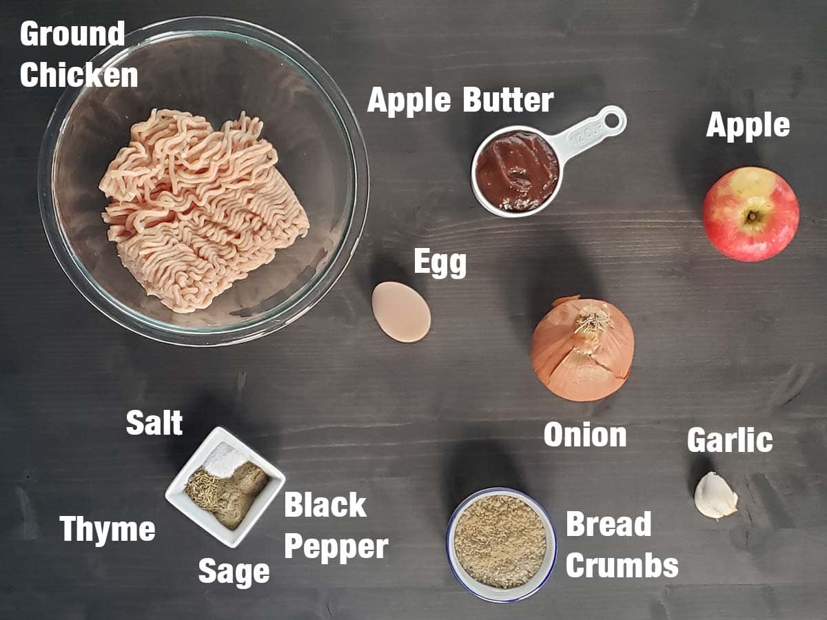 Chicken apple meatball ingredients on a dark wood surface.