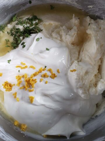 Cheesecake filling ingredients in a metal bowl.