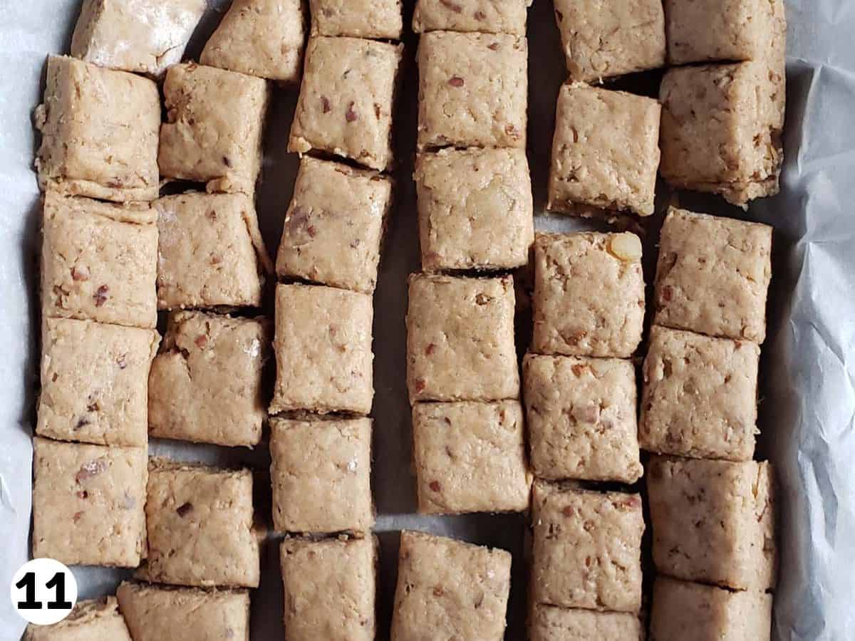 Sone dough cut into squares on parchment paper.
