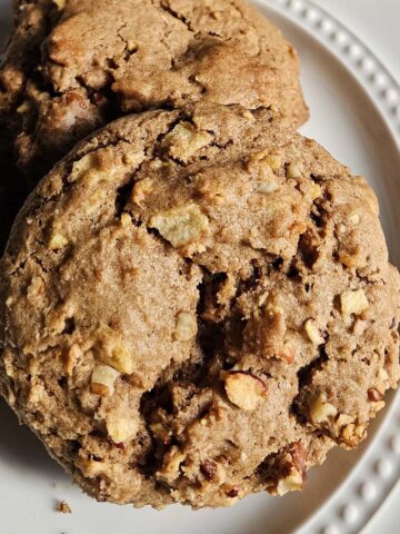 Pile of sourdough apple cookies on a white plate.