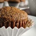 Close up of a gingerbread muffin with the paper partially peeled away.