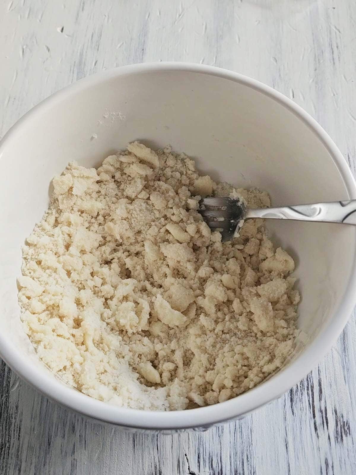 Streusel ingredients crumbled together in a white bowl.