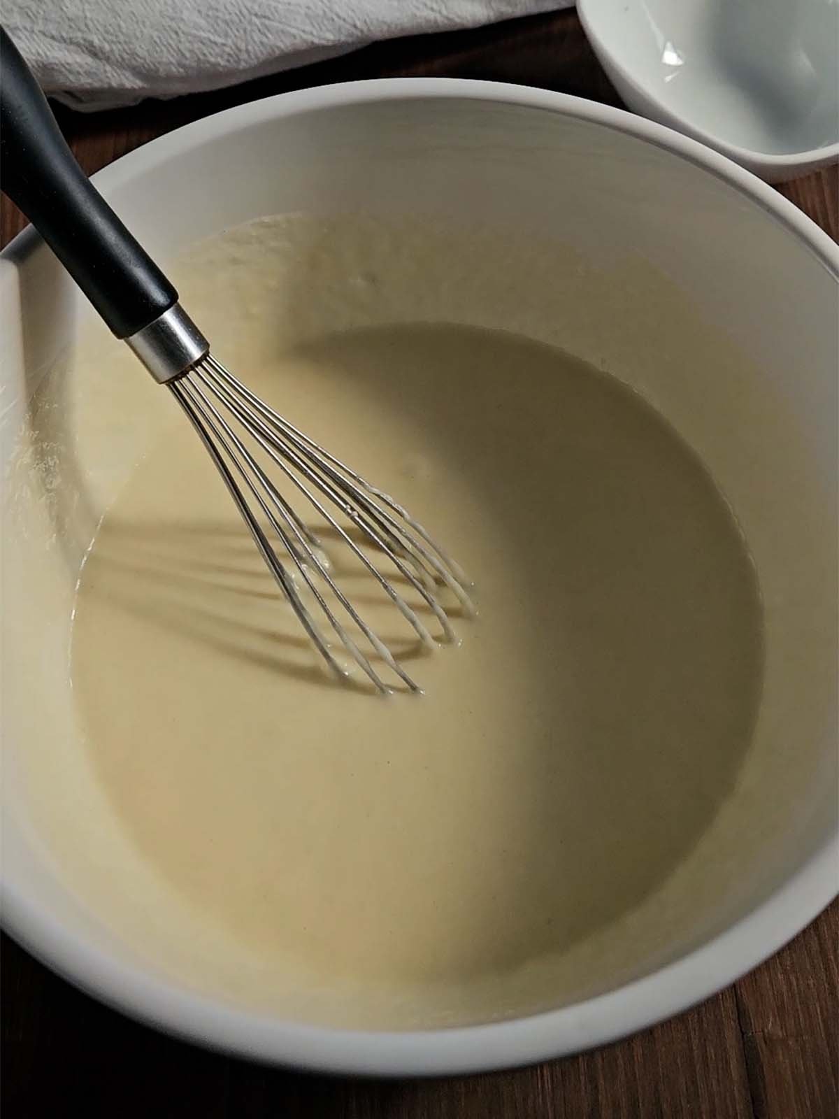 Sourdough pancake wet ingredients in a white bowl.