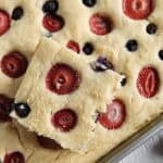 Sheet pan pancake with berries in a metal pan.