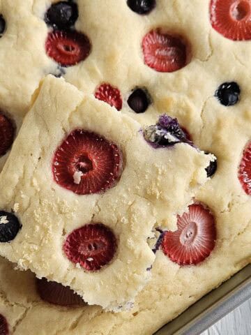 Sheet pan pancake with berries in a metal pan.