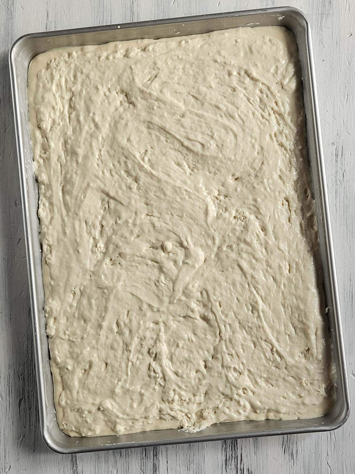 Unbaked sheet pan pancake in a metal pan.