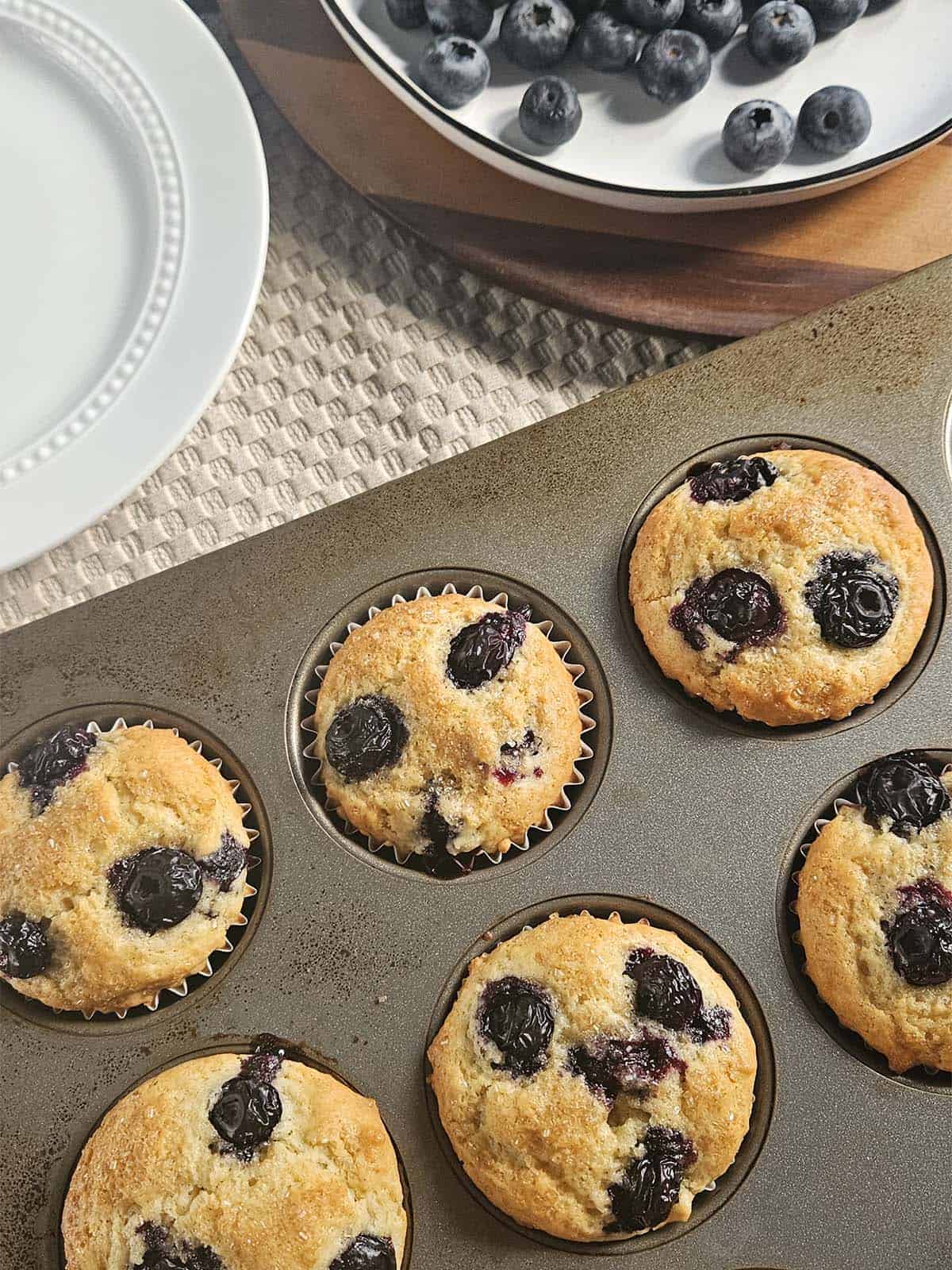 Sourdough blueberry muffins in a muffin pan.